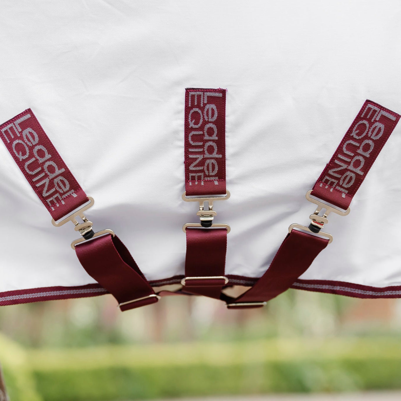 triple surcingle detail shown of white horse rug with red trim, by leader equine