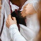 close up of person closing the front of a white horse rug on a bay horse