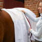 woman in equestrian apparel showing the inner lining details of the canberra fleece lined sheet on a horse