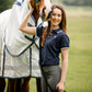 woman equestrian wearing navy polo tshirt with grey breeches standing with bay horse in white and navy cotton rug