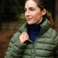 Woman wearing a green puffer jacket in a forest setting