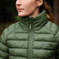 Person wearing a green puffer jacket with a brand logo, standing outdoors.