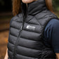 Person wearing a black puffer vest with Leader Equine logo outdoors