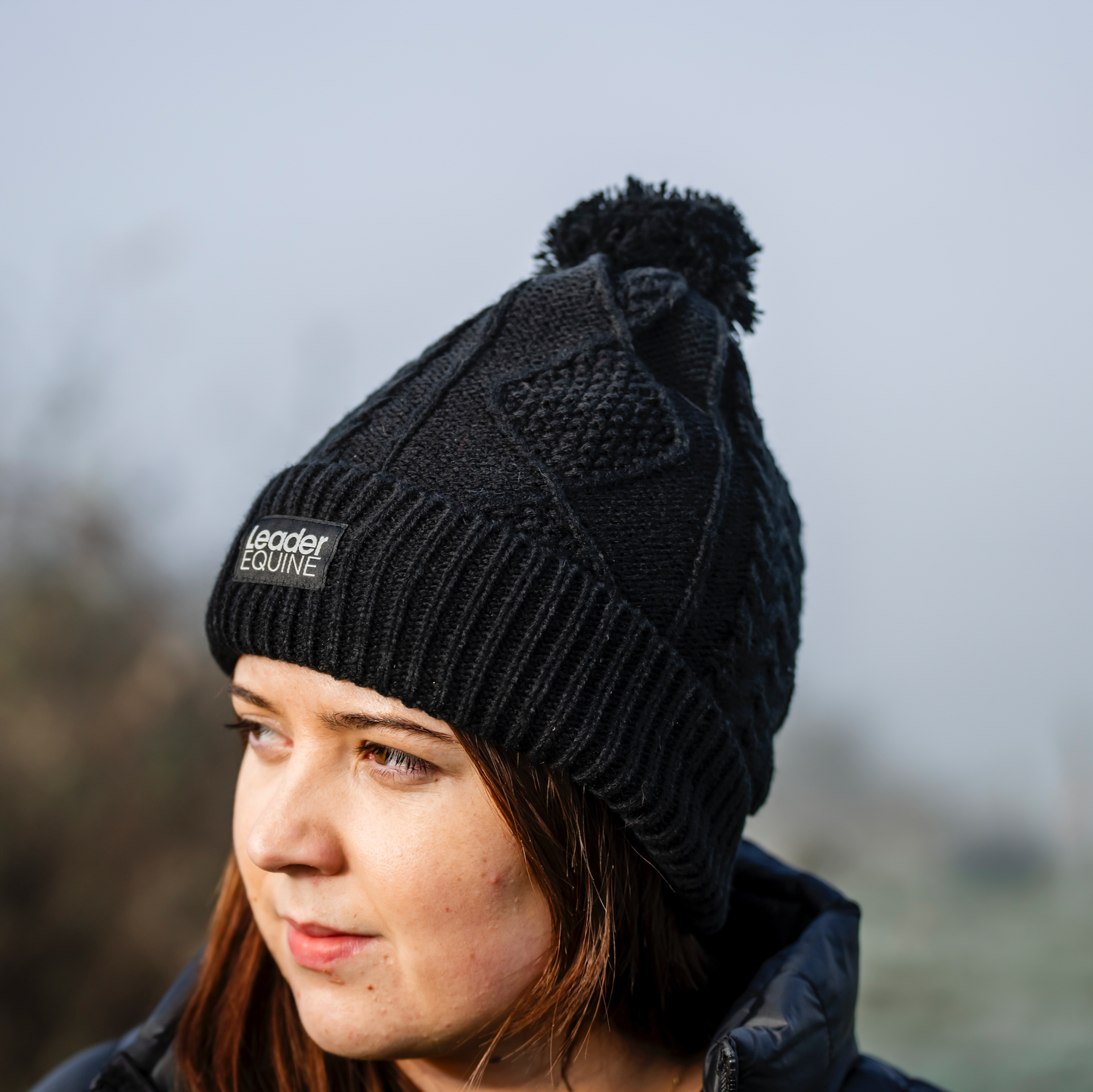 girl wearing black knitted beanie with logo from leader equine